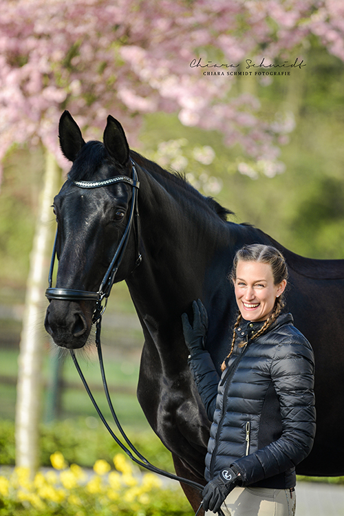 Reiterin und Pferd stehen nebeneinander