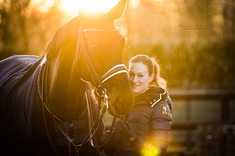 Reiterin steht neben ihrem Pferd